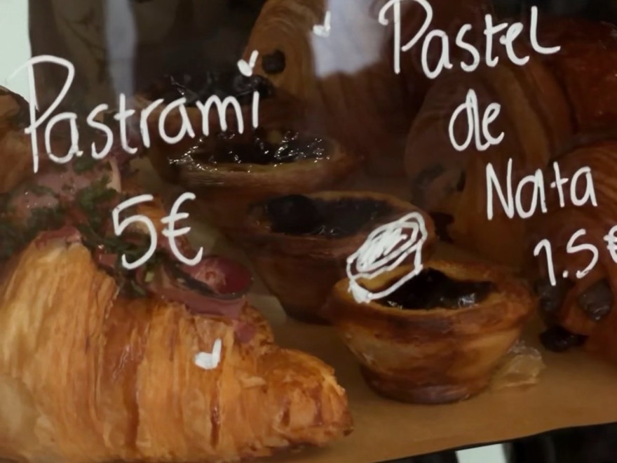 Pastéis de nata and croissants behind a bakery window