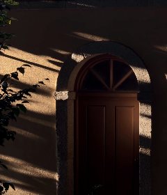An arched door in late afternoon shadows