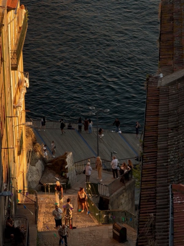 Stone steps leading down to the river, people walking along the quay